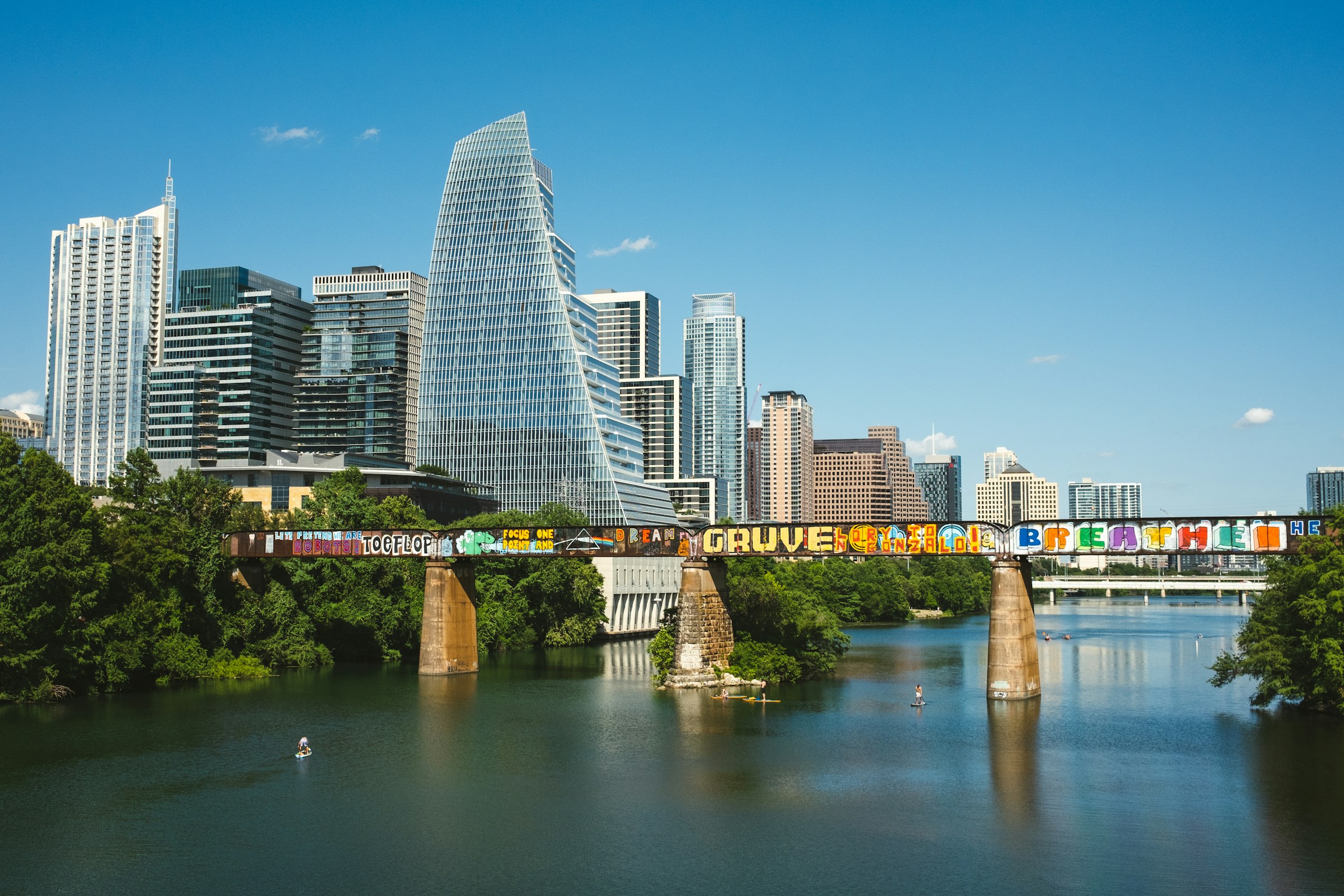 Downtown Austin rises beyond the railroad bridge over Lady Bird Lake.
